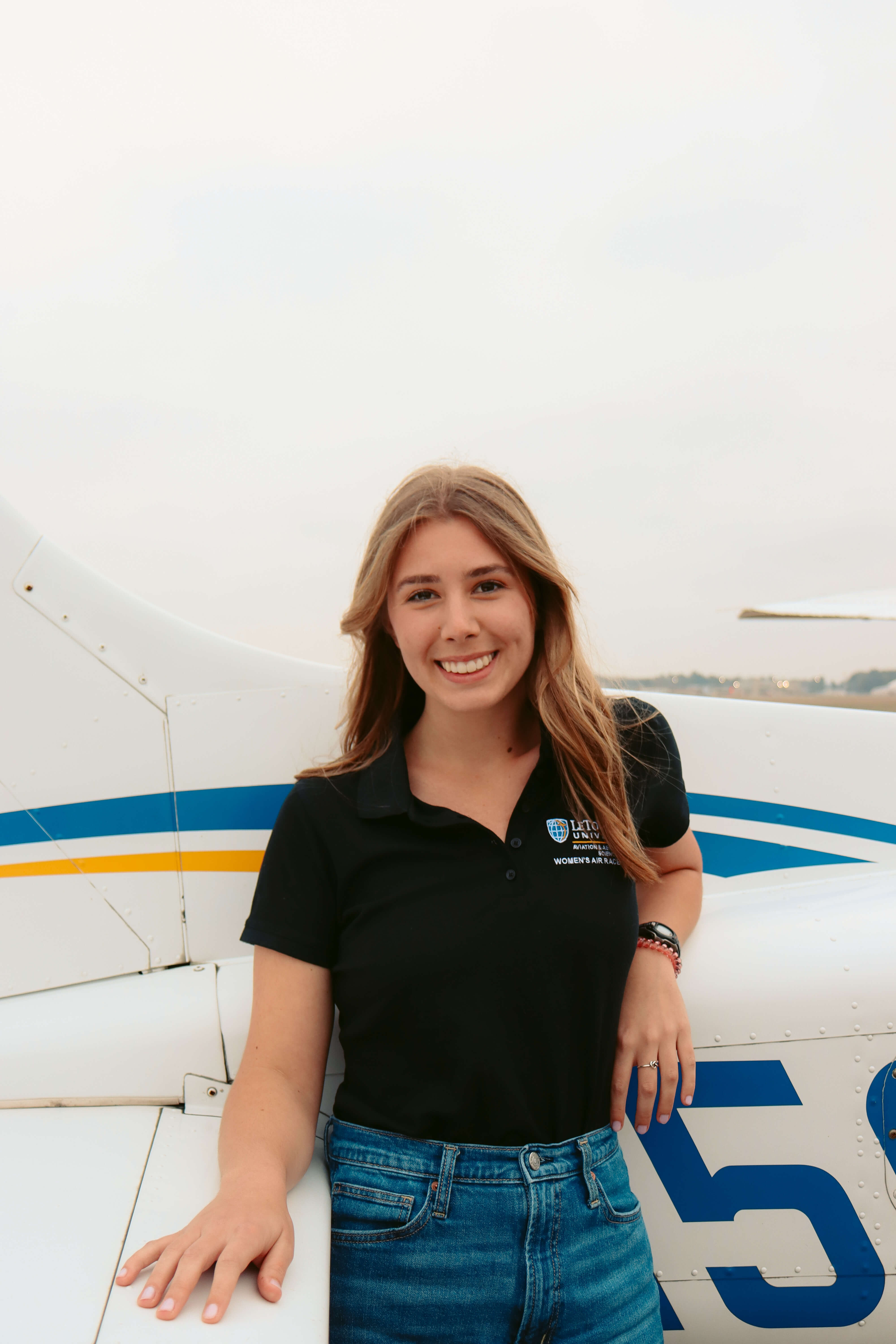 women in front of plane