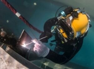 A U.S. Navy diver practices underwater welding in a training pool